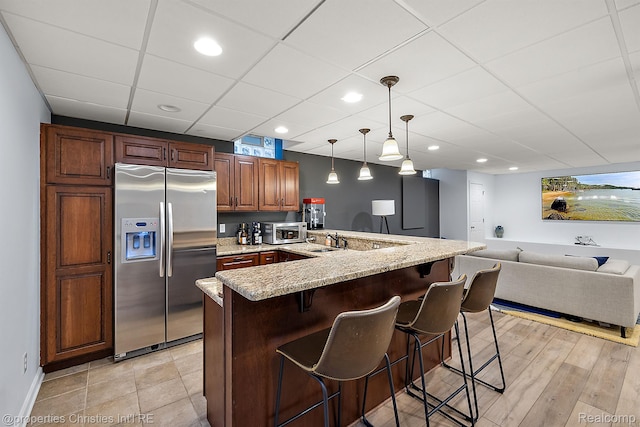1174 Lakeside Dr, Birmingham, MI 48009 - kitchen with stainless steel appliances, a kitchen breakfast bar, light stone countertops, open floor plan, and hanging light fixtures