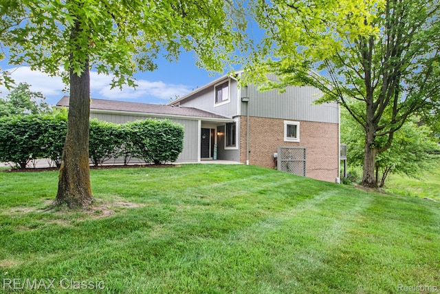 854 Yorktown Ct, Northville, MI 48167 - rear view of house with a yard and brick siding