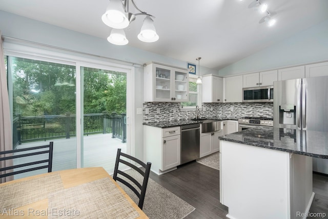 3527 Applewood Ln Unit 2, Grand Blanc, MI 48439 - kitchen featuring appliances with stainless steel finishes, a chandelier, tasteful backsplash, lofted ceiling, and glass insert cabinets