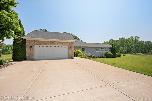 8922 Mcclements Rd, Brighton, MI 48114 - view of front of house featuring brick siding, a front yard, driveway, and a garage