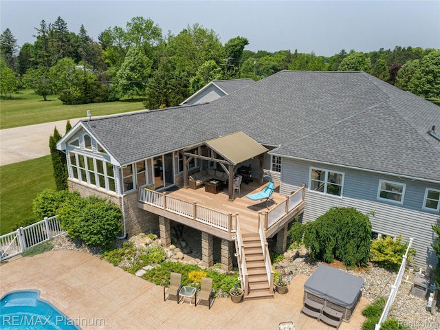 8922 Mcclements Rd, Brighton, MI 48114 - rear view of property featuring a deck, a hot tub, a shingled roof, stairway, and an outdoor pool