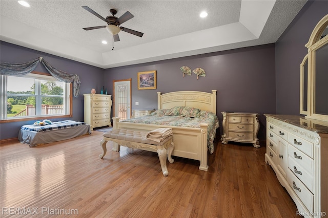 8922 Mcclements Rd, Brighton, MI 48114 - bedroom featuring a textured ceiling, a raised ceiling, wood finished floors, recessed lighting, and ceiling fan