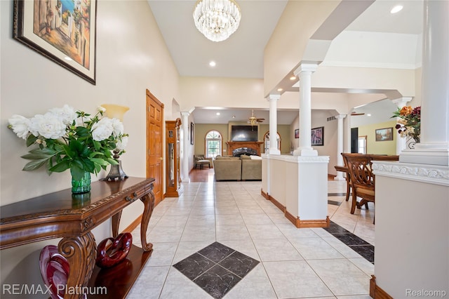8922 Mcclements Rd, Brighton, MI 48114 - foyer entrance with ornate columns, light tile patterned floors, a fireplace, recessed lighting, and a chandelier
