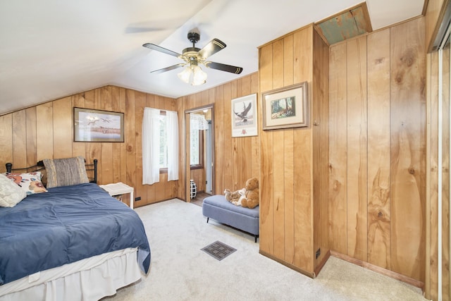 3750 River Rd, Manistee, MI 49660 - carpeted bedroom with wooden walls, vaulted ceiling, and a ceiling fan
