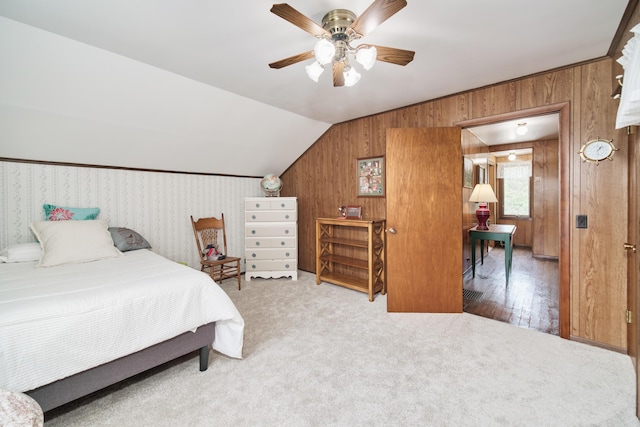 3750 River Rd, Manistee, MI 49660 - bedroom with wooden walls, carpet floors, vaulted ceiling, and a ceiling fan