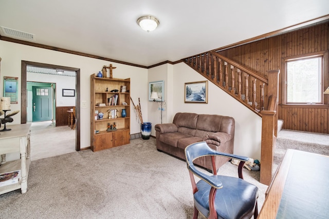 3750 River Rd, Manistee, MI 49660 - carpeted living area featuring wood walls, stairs, and ornamental molding
