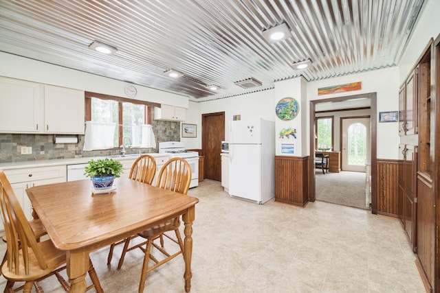 3750 River Rd, Manistee, MI 49660 - dining room featuring a wainscoted wall, healthy amount of natural light, light flooring, and wooden walls