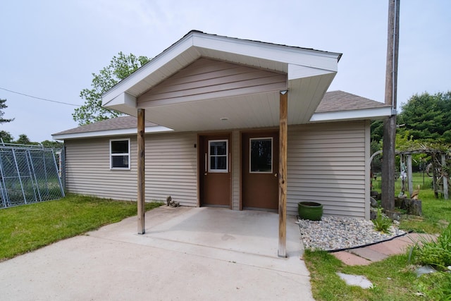 3750 River Rd, Manistee, MI 49660 - view of front of house with a shingled roof and a patio