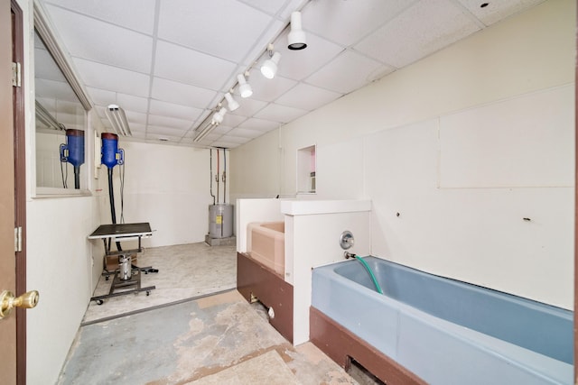 3750 River Rd, Manistee, MI 49660 - full bath featuring a garden tub, electric water heater, a paneled ceiling, and unfinished concrete floors