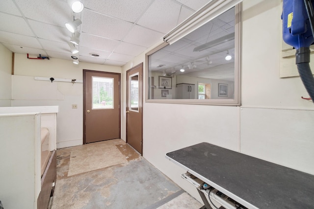 3750 River Rd, Manistee, MI 49660 - doorway to outside featuring rail lighting, healthy amount of natural light, a paneled ceiling, and unfinished concrete floors