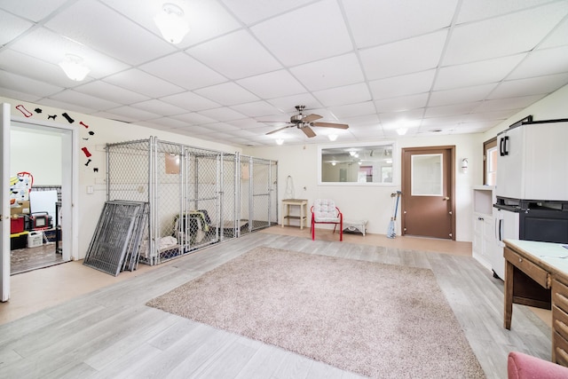 3750 River Rd, Manistee, MI 49660 - miscellaneous room featuring a drop ceiling, ceiling fan, and light wood-style flooring