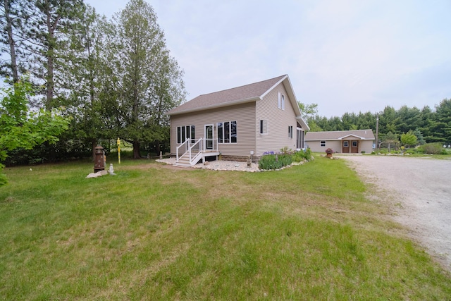 3750 River Rd, Manistee, MI 49660 - rear view of house with a yard and driveway