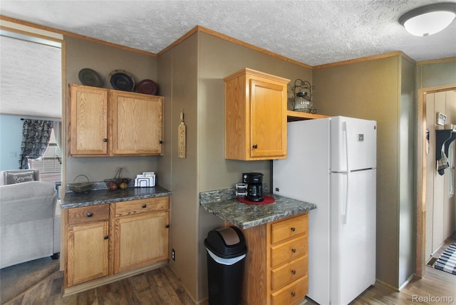 13482 Pear St, Carleton, MI 48117 - kitchen with freestanding refrigerator, dark wood-type flooring, a textured ceiling, dark countertops, and ornamental molding