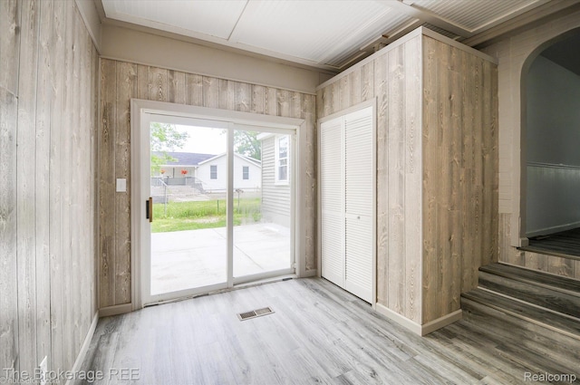 1372 S Packard Ave, Burton, MI 48509 - unfurnished dining area featuring arched walkways, wood finished floors, and wood walls