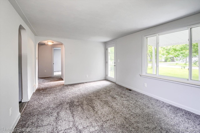 1372 S Packard Ave, Burton, MI 48509 - spare room featuring arched walkways and carpet flooring