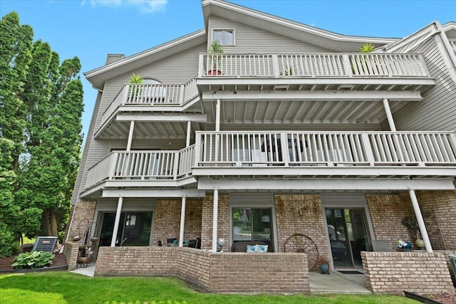 21112 Boulder Cir, Northville, MI 48167 - rear view of house with a balcony, brick siding, and a patio area