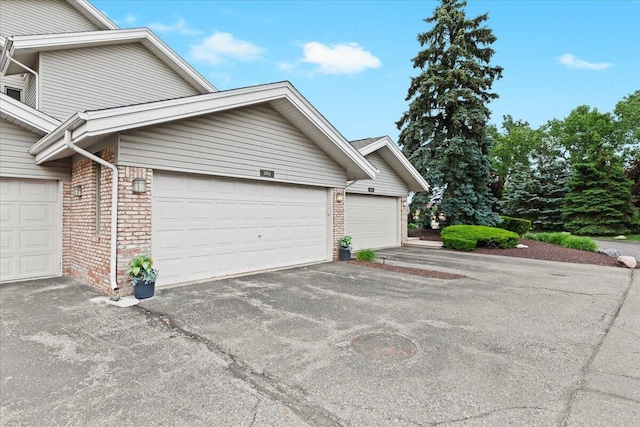 21112 Boulder Cir, Northville, MI 48167 - view of property exterior with brick siding, driveway, and an attached garage