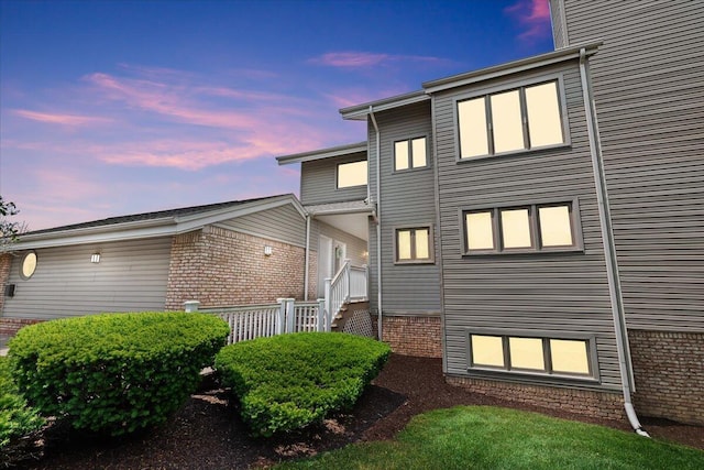 21112 Boulder Cir, Northville, MI 48167 - back of house at dusk featuring brick siding