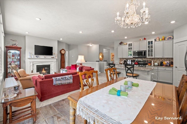 4441 Koinonia Dr NE Unit 3, Grand Rapids, MI 49525 - dining space with recessed lighting, a chandelier, and a glass covered fireplace
