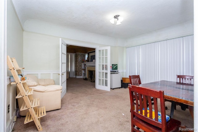 318 Chandler St, Detroit, MI 48202 - carpeted dining area featuring french doors, a fireplace, a wainscoted wall, and a decorative wall