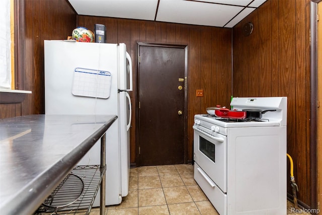 318 Chandler St, Detroit, MI 48202 - kitchen with white appliances, light tile patterned flooring, wood walls, and stainless steel countertops