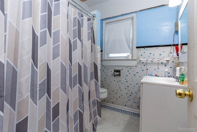 318 Chandler St, Detroit, MI 48202 - full bathroom with vanity, curtained shower, tile patterned floors, tile walls, and a wainscoted wall