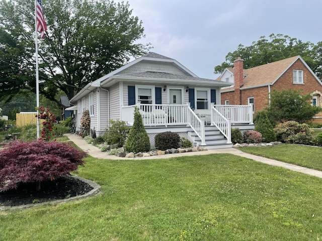 108 S Berrien St, New Buffalo, MI 49117 - view of front of property featuring covered porch, a front yard, and a shingled roof