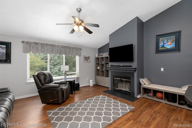 1232 Michael Dr, Westland, MI 48186 - living area with vaulted ceiling, a glass covered fireplace, ceiling fan, and wood finished floors