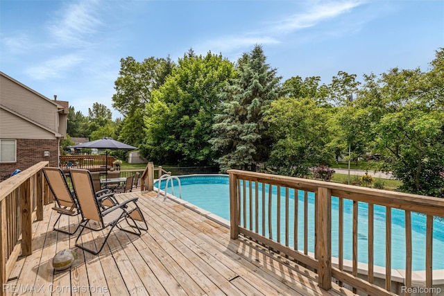 1232 Michael Dr, Westland, MI 48186 - deck with an outdoor pool, outdoor dining space, and view of wooded area