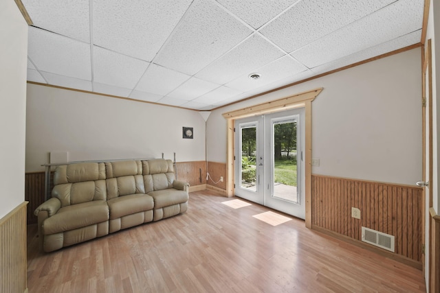4787 Hooks Mill Rd, Adrian, MI 49221 - unfurnished living room featuring a wainscoted wall, french doors, wood walls, wood finished floors, and a paneled ceiling