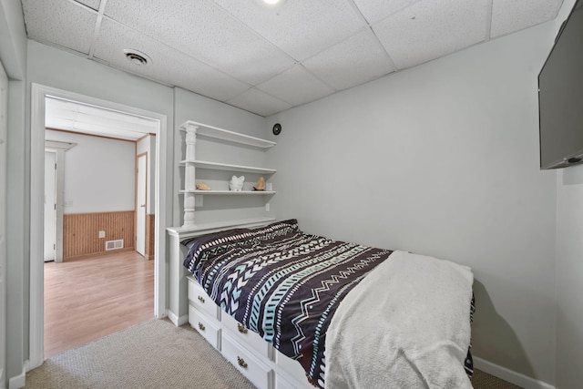 4787 Hooks Mill Rd, Adrian, MI 49221 - carpeted bedroom featuring a paneled ceiling, a wainscoted wall, and wood walls
