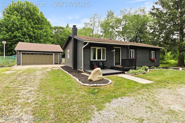 10129 Nimphie Rd, Fenton, MI 48430 - ranch-style home featuring a chimney, an outdoor structure, a front yard, a porch, and a detached garage