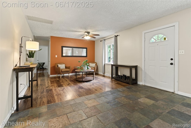 10129 Nimphie Rd, Fenton, MI 48430 - foyer entrance featuring a textured ceiling, a ceiling fan, and stone tile flooring