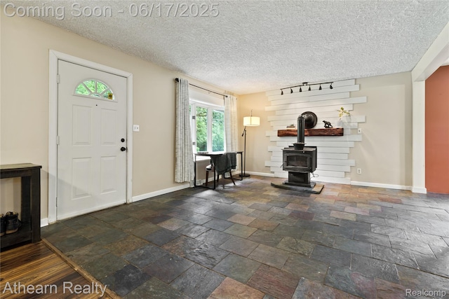 10129 Nimphie Rd, Fenton, MI 48430 - foyer entrance with a wood stove, stone tile flooring, and a textured ceiling