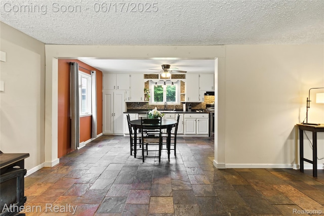 10129 Nimphie Rd, Fenton, MI 48430 - dining area featuring a ceiling fan, stone tile flooring, and a textured ceiling
