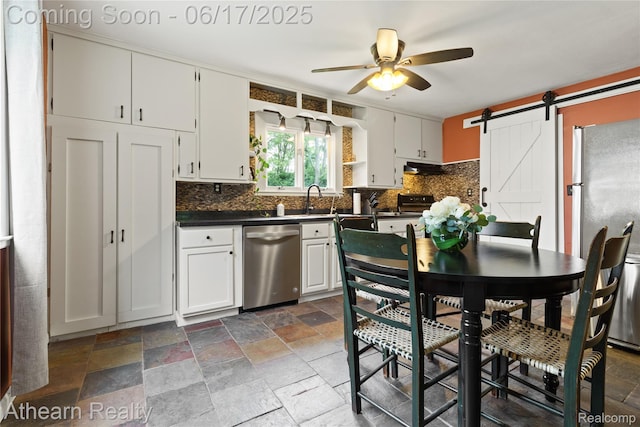 10129 Nimphie Rd, Fenton, MI 48430 - kitchen with dishwasher, dark countertops, a ceiling fan, backsplash, and stone tile flooring
