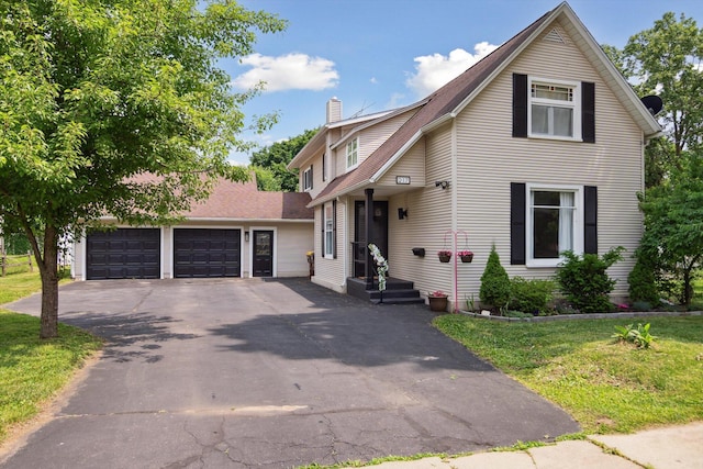 217 S Marshall Ave, Marshall, MI 49068 - view of front facade featuring driveway, a chimney, a garage, and a front yard