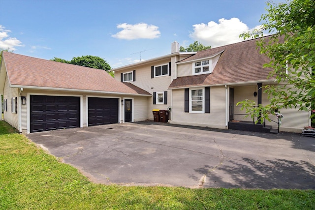 217 S Marshall Ave, Marshall, MI 49068 - view of front of house with an attached garage, a chimney, driveway, and roof with shingles