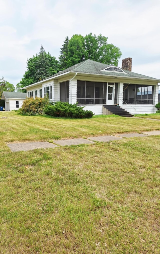 624 N Main St, Evart, MI 49631 - ranch-style house featuring a sunroom, a chimney, and a front lawn