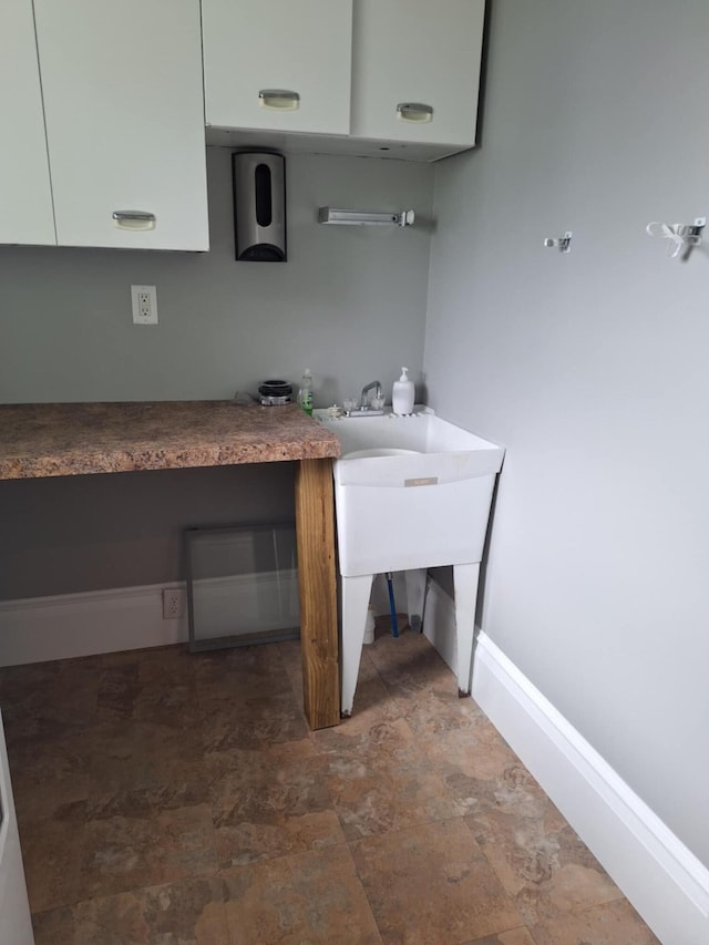 624 N Main St, Evart, MI 49631 - kitchen with white cabinetry, stone finish flooring, and built in study area