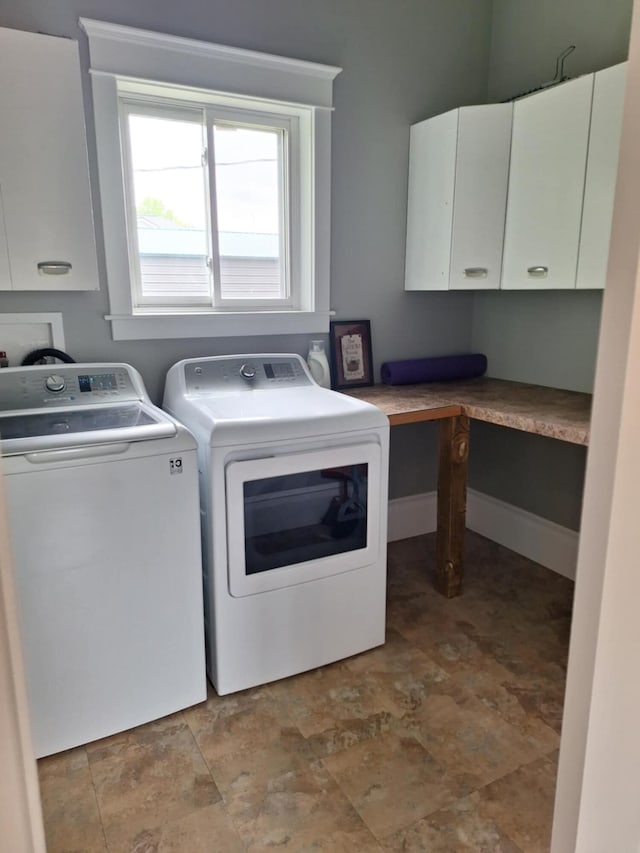 624 N Main St, Evart, MI 49631 - laundry area featuring cabinet space, washing machine and clothes dryer, and stone finish floors