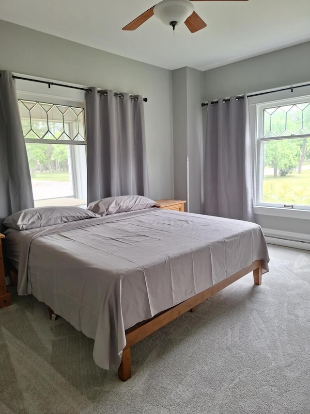 624 N Main St, Evart, MI 49631 - carpeted bedroom with baseboard heating and ceiling fan