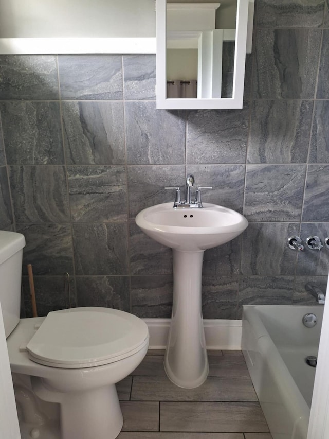624 N Main St, Evart, MI 49631 - full bath featuring a bath, tile walls, and wood finish floors