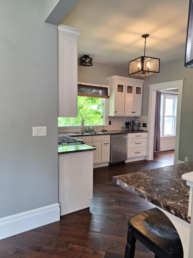 624 N Main St, Evart, MI 49631 - kitchen with dishwasher, decorative backsplash, white cabinets, dark wood finished floors, and decorative light fixtures