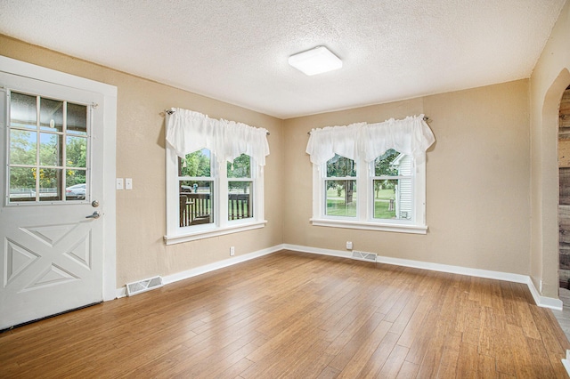 8464 E Michigan Ave, Galesburg, MI 49053 - foyer with plenty of natural light, arched walkways, hardwood / wood-style flooring, and a textured ceiling