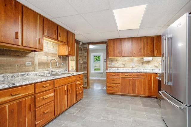 8464 E Michigan Ave, Galesburg, MI 49053 - kitchen featuring high end refrigerator, decorative backsplash, a drop ceiling, brown cabinetry, and light stone counters