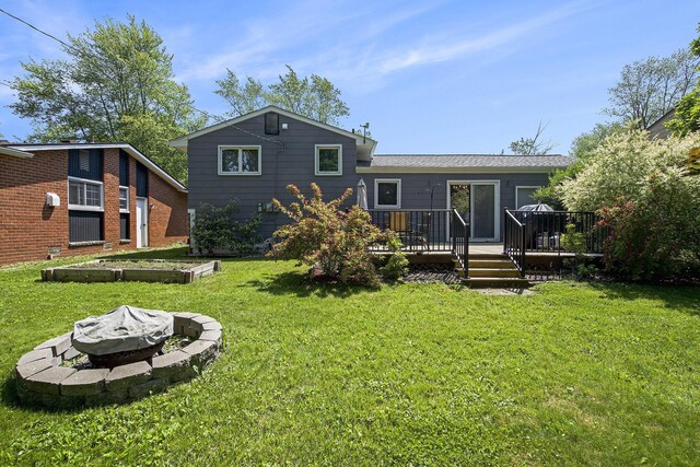 8683 Hemlock Ct, Ypsilanti, MI 48198 - rear view of house featuring a fire pit, a yard, and a deck