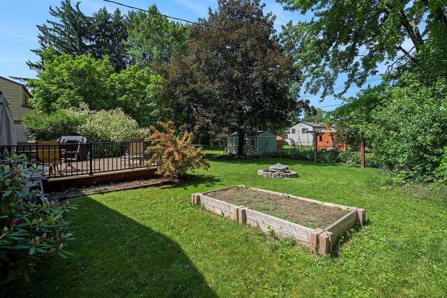 8683 Hemlock Ct, Ypsilanti, MI 48198 - view of yard with a storage shed, a fire pit, and a deck