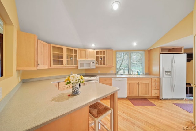 5027 Belemere Ct, Manitou Beach, MI 49253 - kitchen with white appliances, light brown cabinets, vaulted ceiling, glass insert cabinets, and light countertops