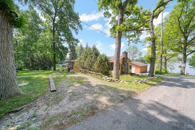5027 Belemere Ct, Manitou Beach, MI 49253 - view of front of house featuring a chimney, a front lawn, and asphalt driveway